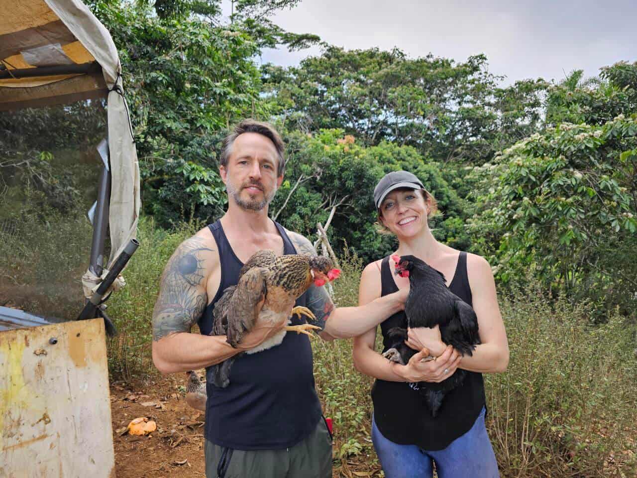 Founders of Rainbow Bridge Hawaii holding chickens on their land