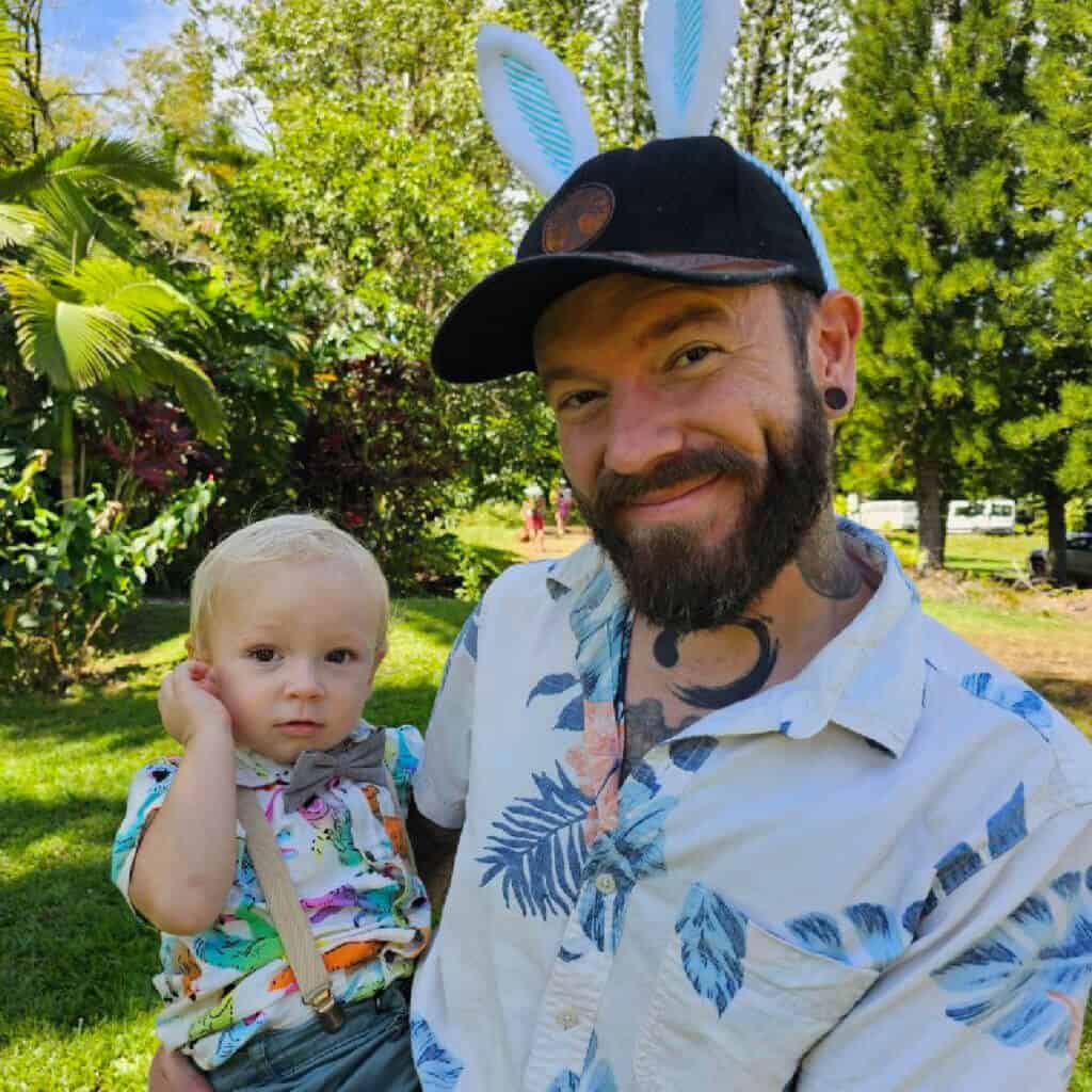 Michael from Rainbow Bridge Hawaii holding his young son outdoors