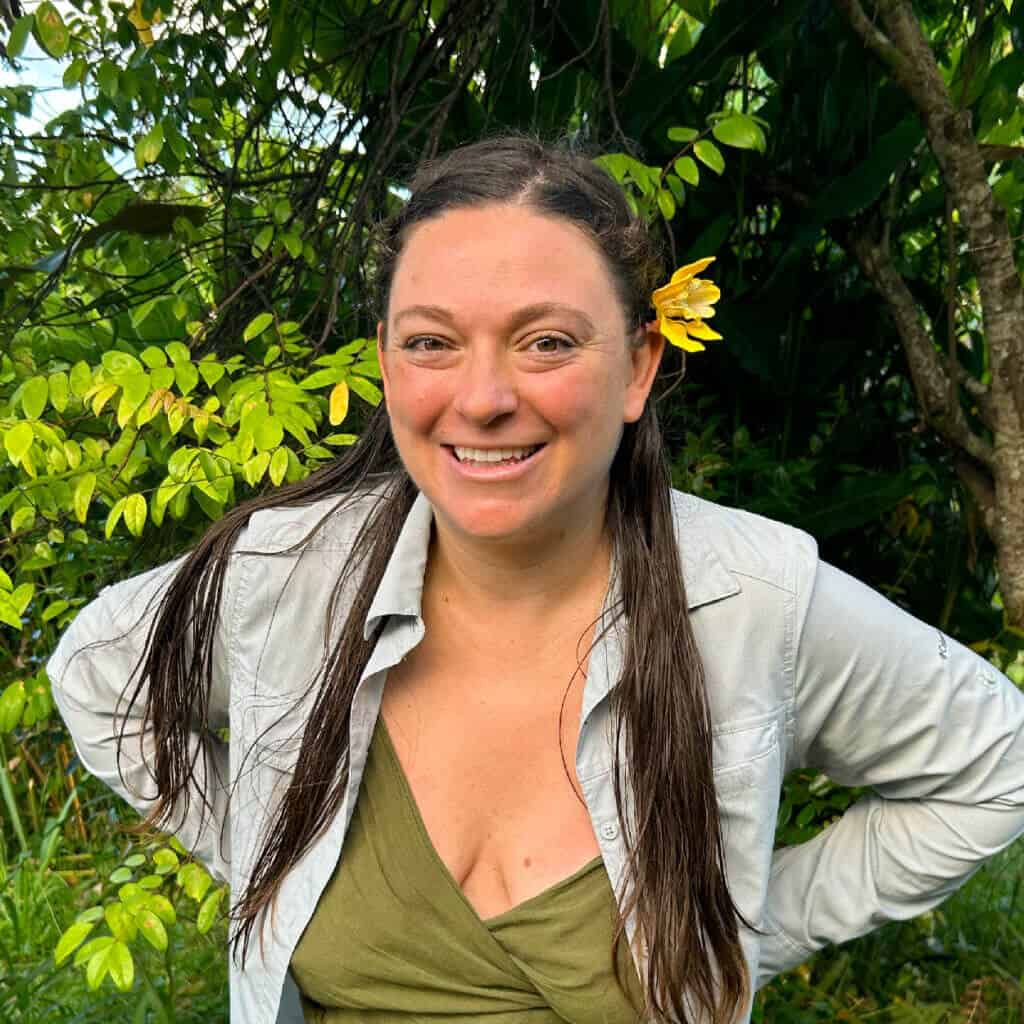 Maomi from Rainbow Bridge Hawaii smiling in the lush community garden on Hawai‘i Island.