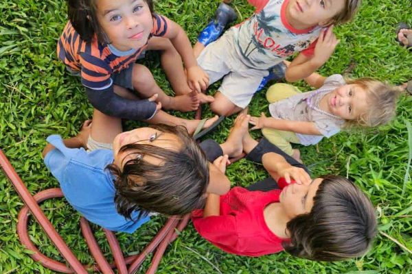 Group of children sitting together on grass during a garden day in Hawaii
